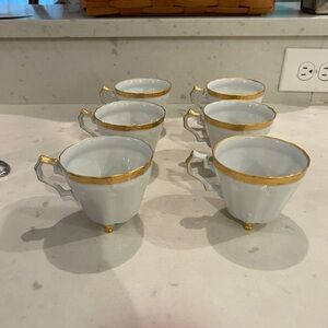 Set of 6 footed white bone china tea cups with gold trim around the rim, handle